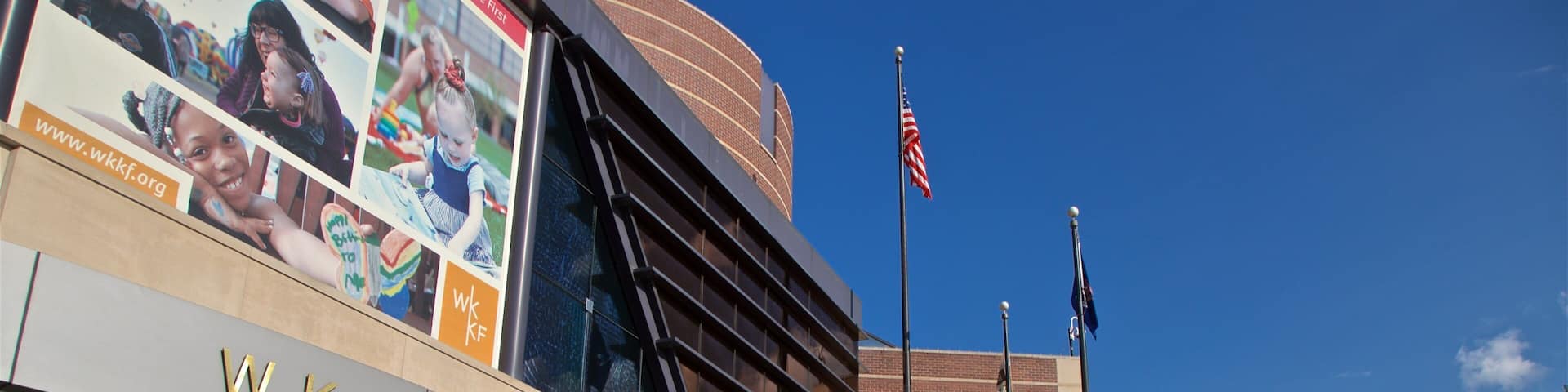 The W.K. Kellogg Foundation building with a large billboard and American flags.