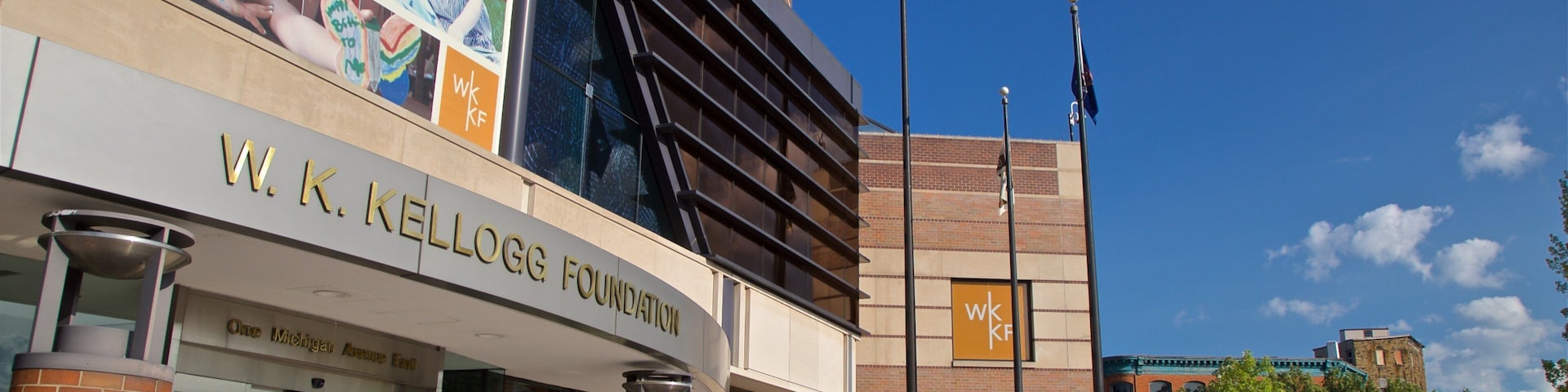 Edificio de la Fundación W.K. Kellogg con un cartel grande y banderas estadounidenses.