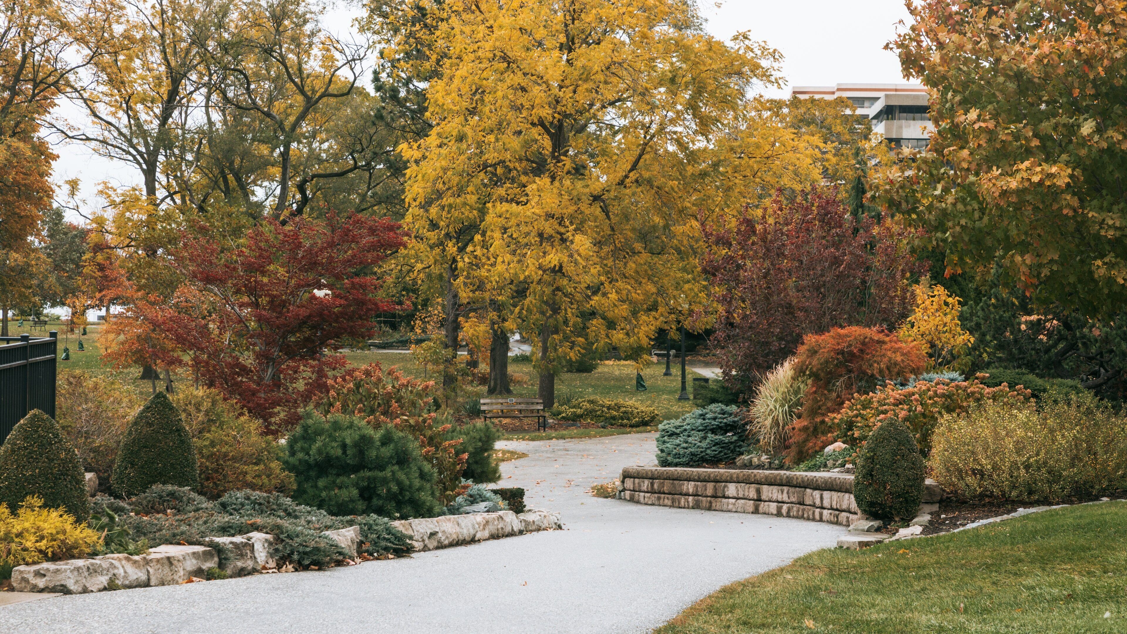 Reaume Park and Coventry Gardens Walking Trails Trailhead featuring autumn leaves and a garden