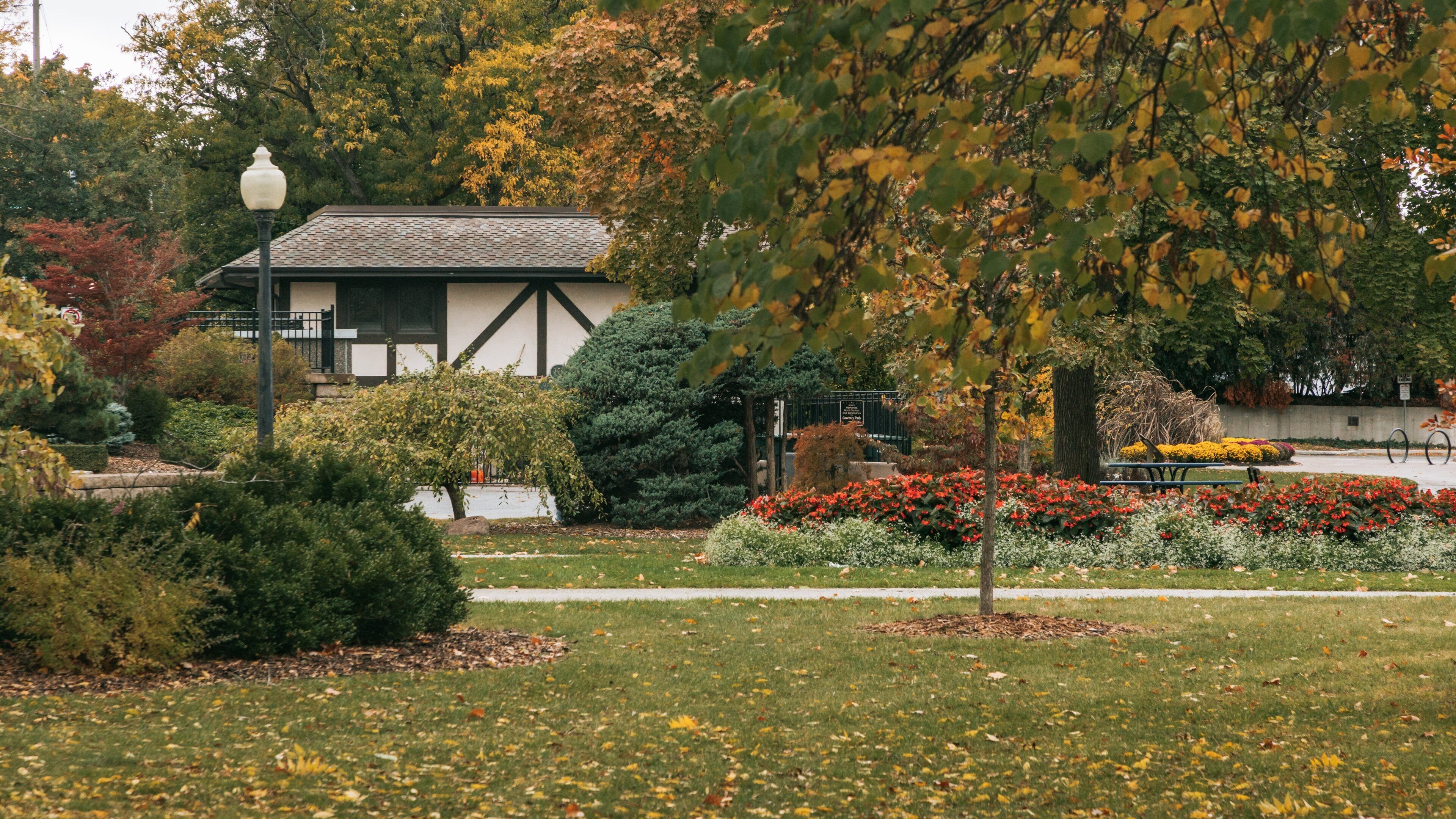 Reaume Park and Coventry Gardens Walking Trails Trailhead showing autumn leaves and a park