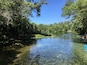 Une rivière aux eaux claires, bordée d’une végétation luxuriante.