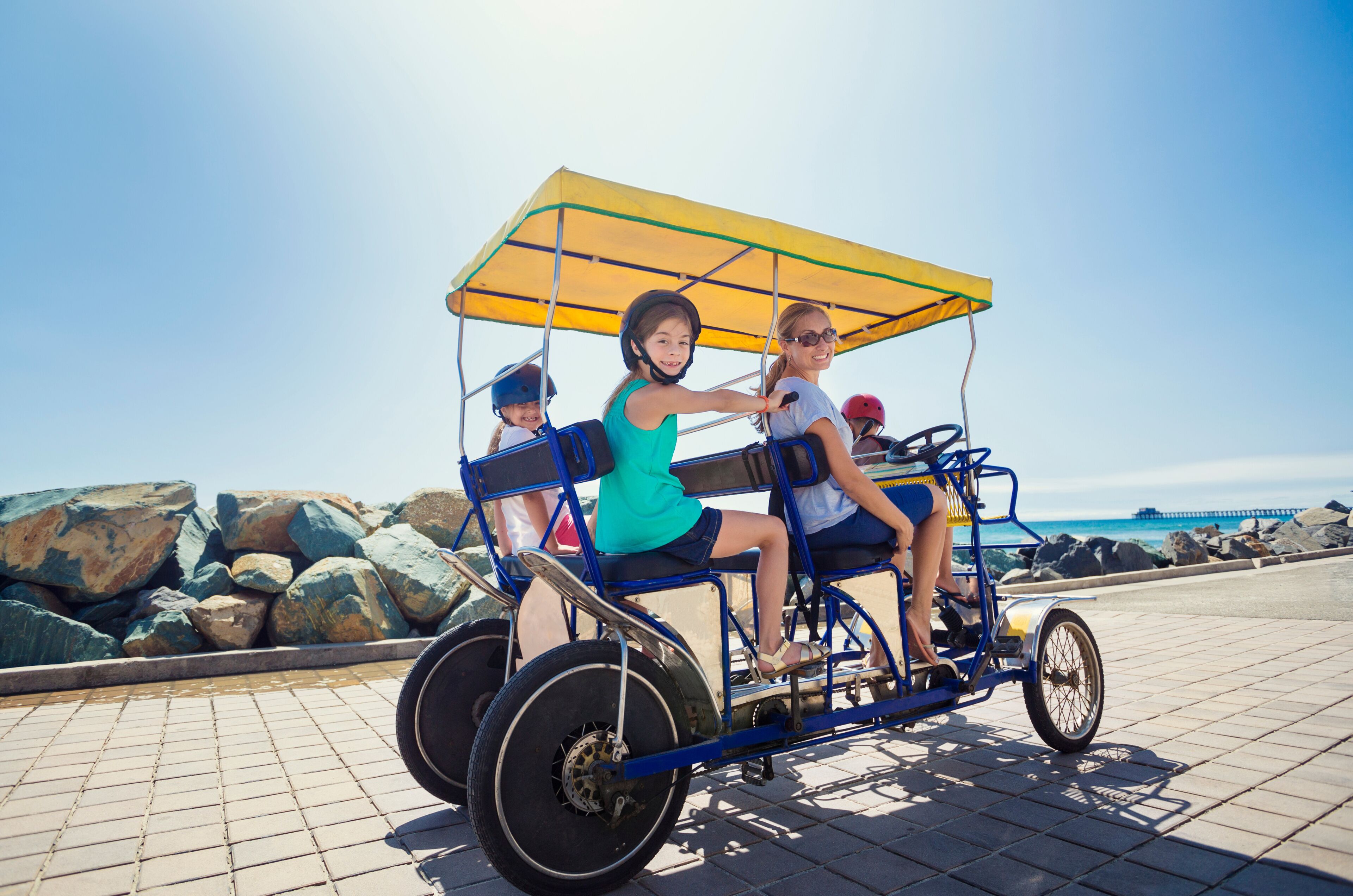 Family on a surrey bike ride along the coast of California