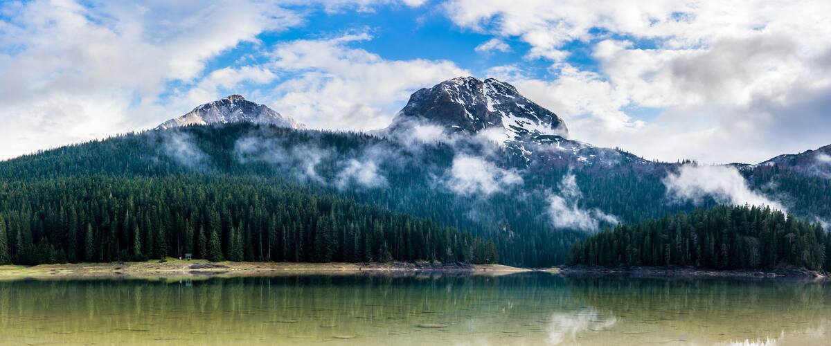 A mountain range with a lake in the foreground.