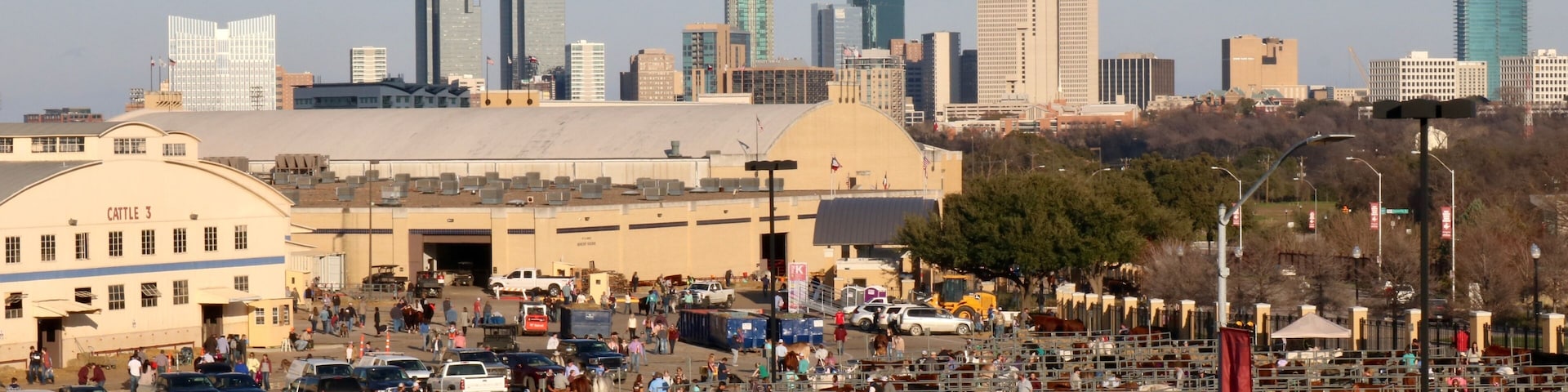Bustling grounds of the stock show and rodeo in Fort Worth with the city's skyline in the background