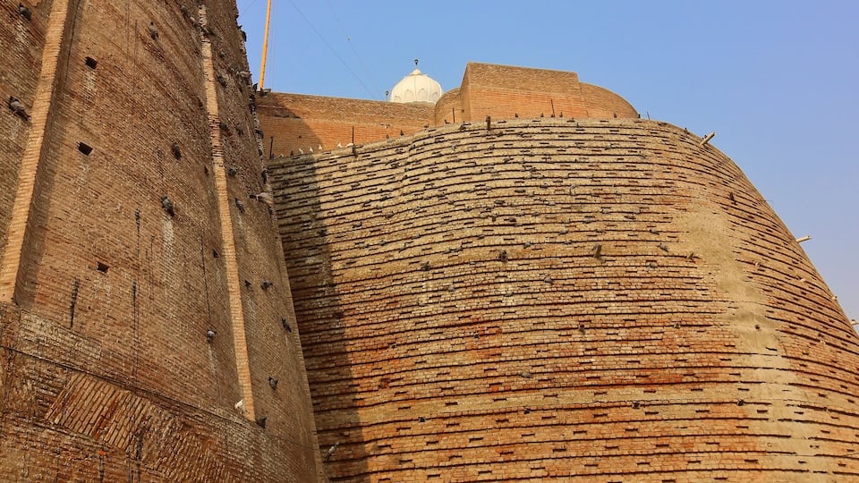 A large brick structure with a dome and a tall tower.