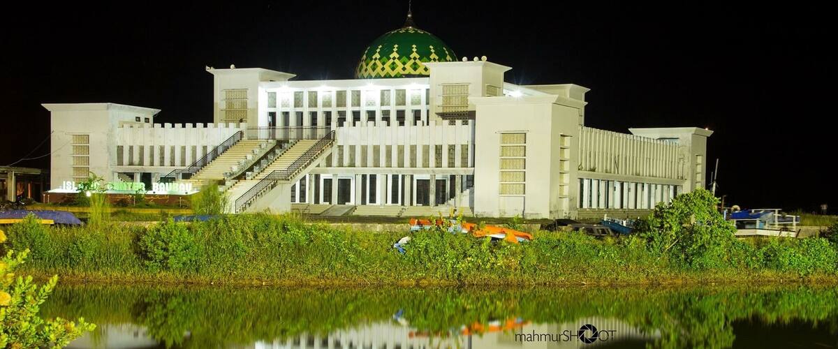 A large building with a green dome and a staircase leading to the entrance.