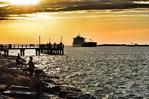 A view of Aransas Pass from the Port Aransas side. At sunset, go get a pizza and watch the ships pass through and dolphins swim nearby. So much to see, and a very relaxing spot. Stay until after dark so that you can hear the dolphins pop up for air in the nearby waters. It's also a great fishing spot.