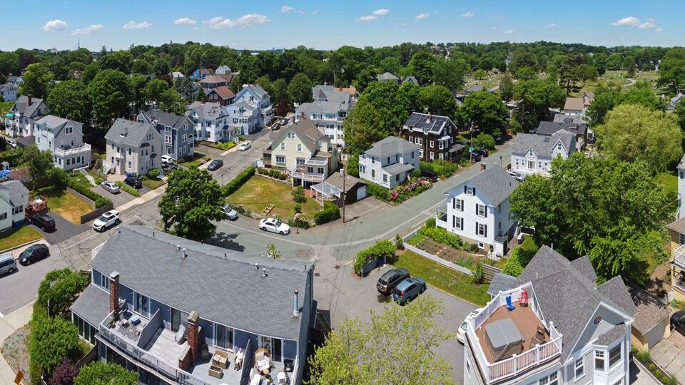 A coastal residential area with houses, a beach, and a road.