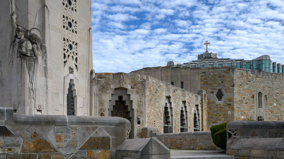 A historic stone building with intricate carvings and a cross on top.