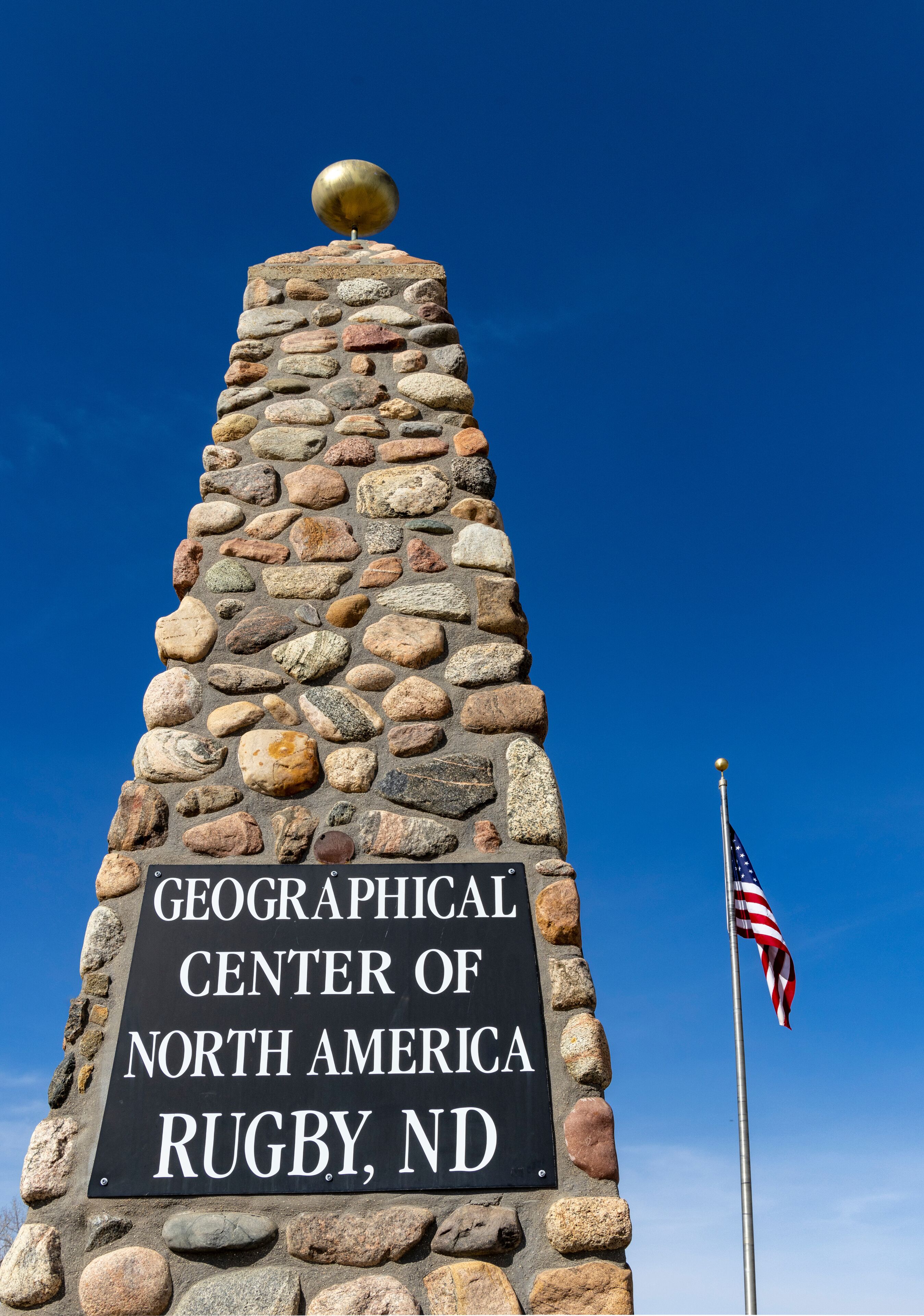 A stone monument with a flagpole and an American flag.