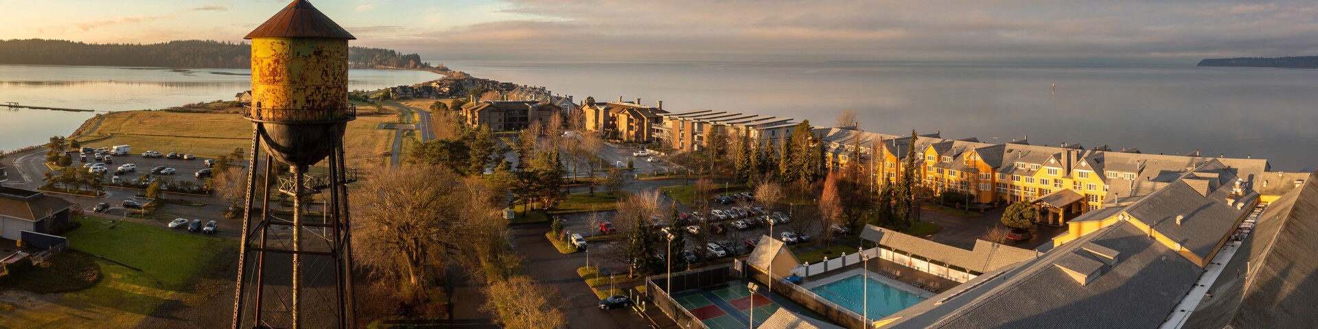 A coastal town with a water tower, a swimming pool, and residential buildings.