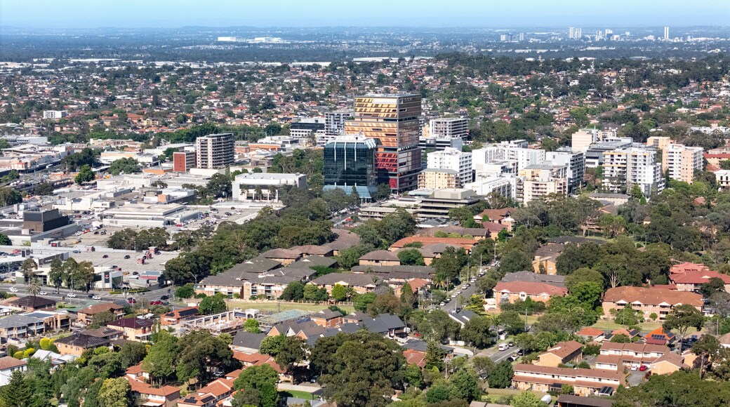 A cityscape with a mix of residential and commercial buildings, including a distinctive modern building with a unique facade.