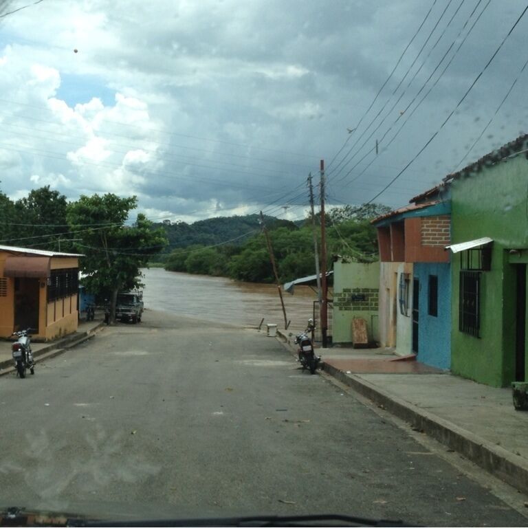 A quiet street with buildings and parked motorcycles.