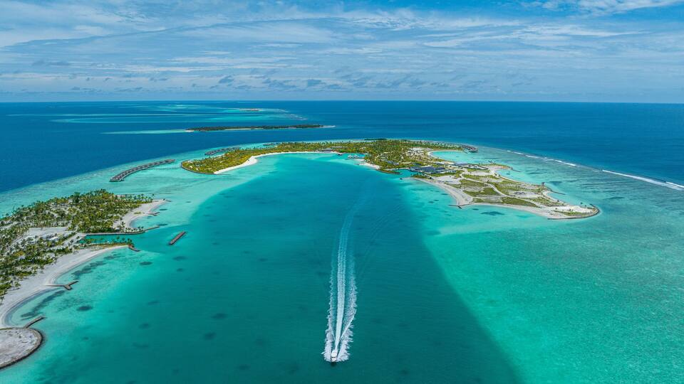 Aerial view of a boat sailing along the coast of Fari Island, Maldives.