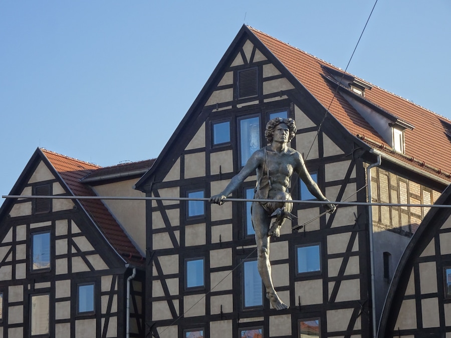 "Man crossing the River" was unveiled on the 1st of May 2004 to commemorate the Polish entry into the European Union. The sculpture was placed on a rope stretched between the banks of the Brda river and was designed so that its centre of gravity is below the wire, which gives it its balance.