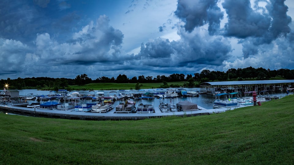 A marina with boats docked under a cloudy sky.