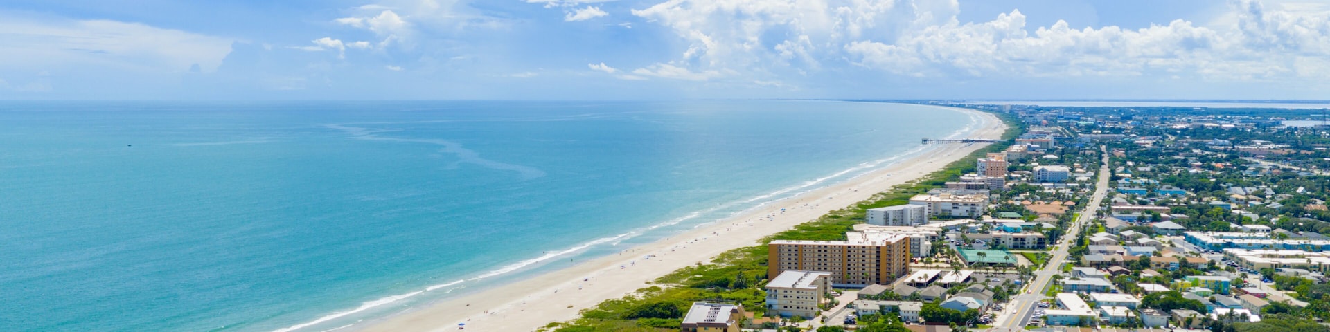 Un pueblo costero con playa, océano y zona residencial.