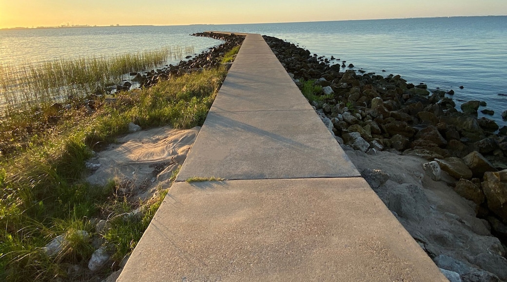 Sunrise concrete pier over water