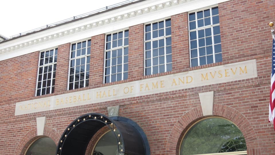 A brick building with a sign reading "National Baseball Hall of Fame and Museum".
