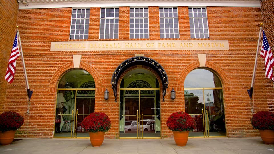 The National Baseball Hall of Fame and Museum entrance with brick walls, arched windows, and American flags.
