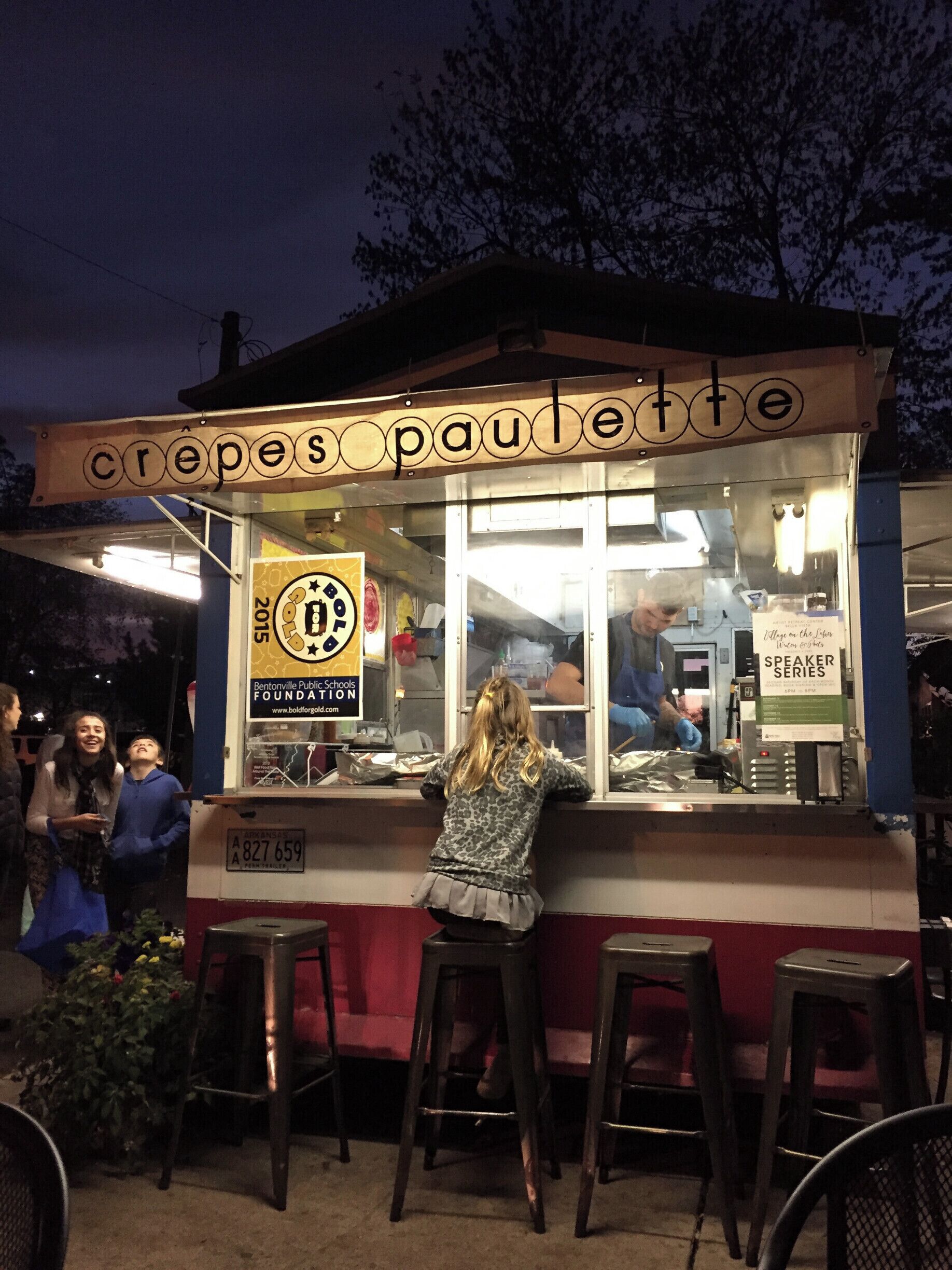 A crepe stand with a sign reading "crepes paullette" and a logo for Bentonville Public Schools Foundation.