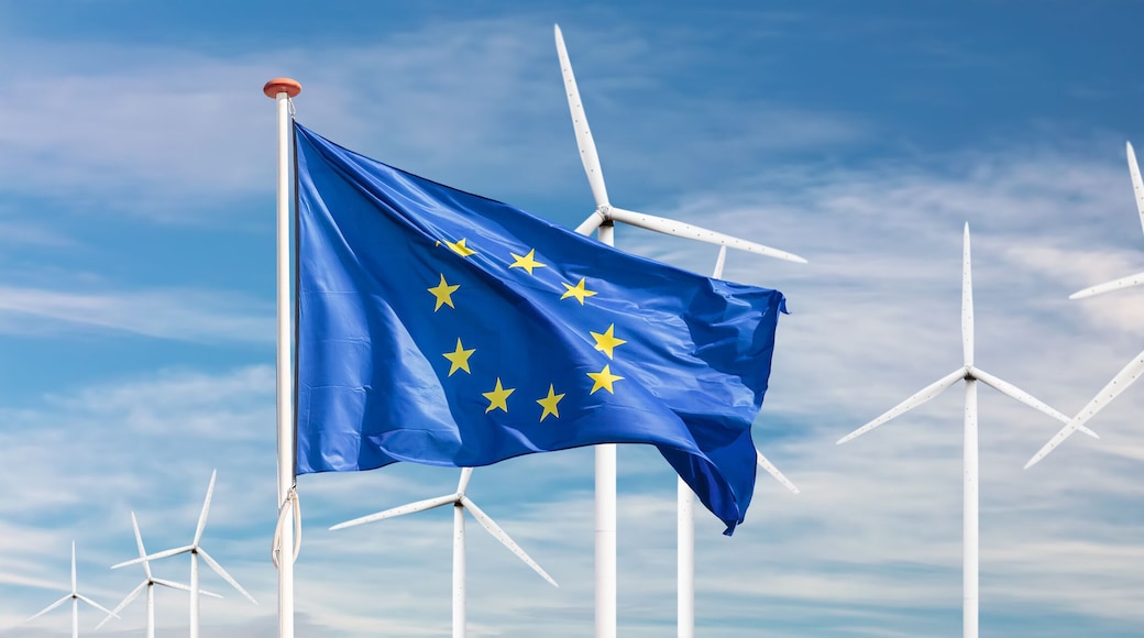 Flag of the European Union in front of a large windpark with wind turbines