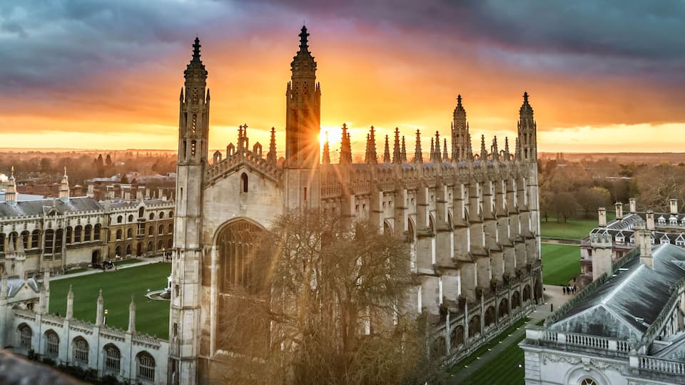 A historic university campus with Gothic architecture, including a prominent clock tower and a large central building.