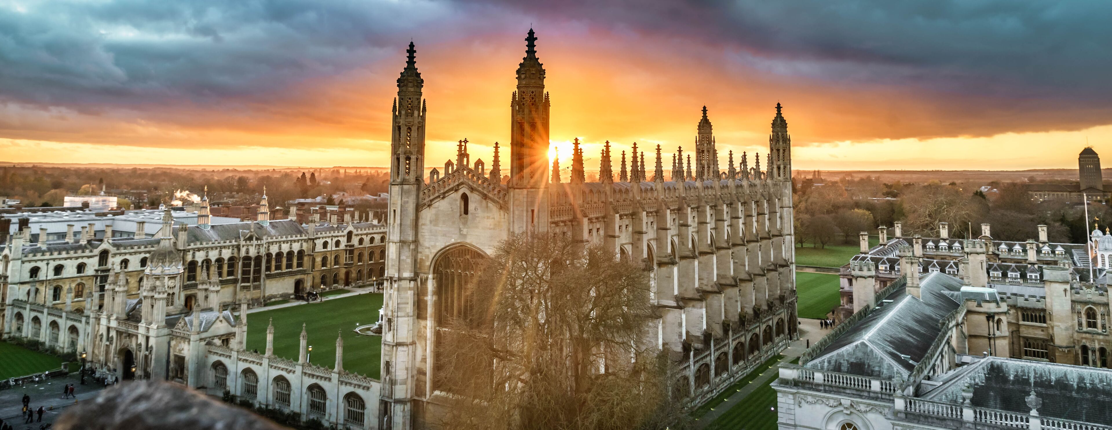 A historic university campus with Gothic architecture, including a prominent clock tower and a large central building.