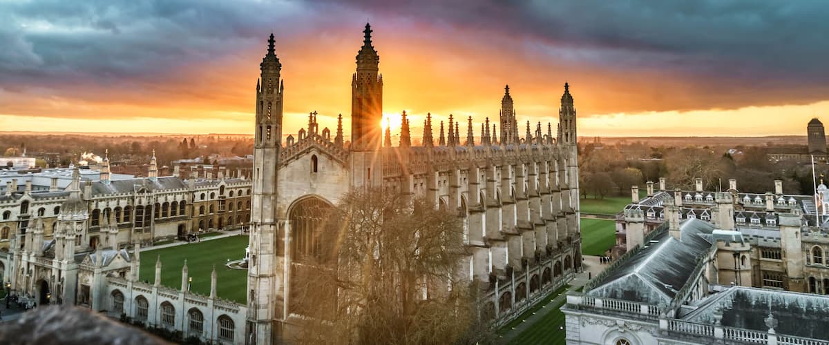 A historic university campus with Gothic architecture, including a prominent clock tower and a large central building.