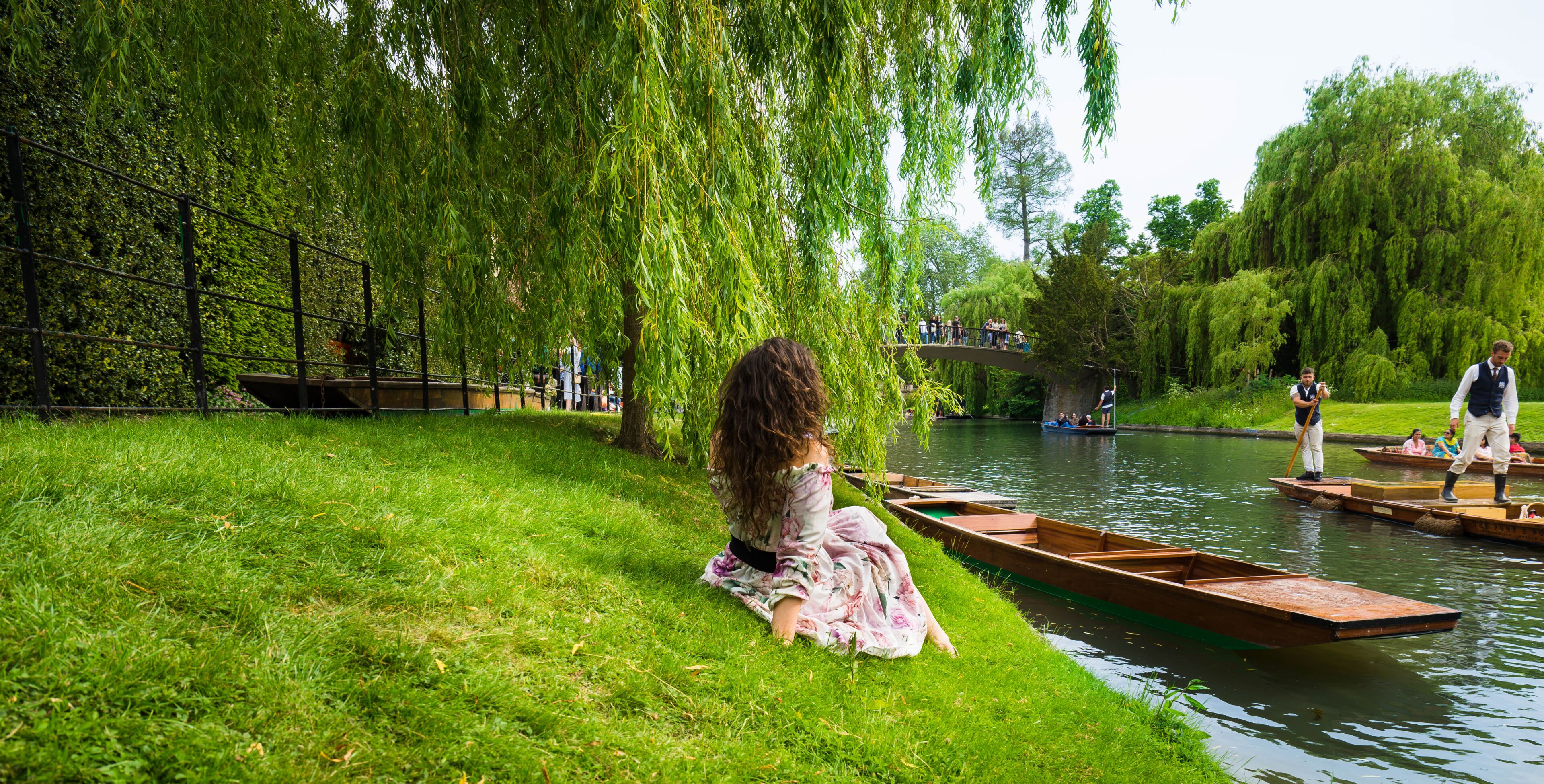 Girl sitting along River Cam near Kings College in the city of Cambridge, United Kingdom