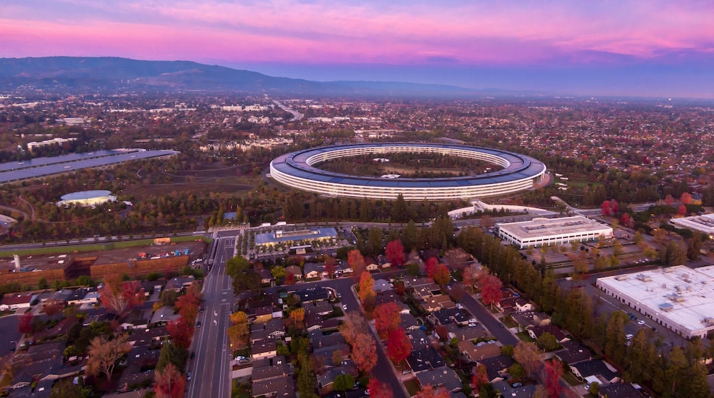 Aerial view of Apple Park headquarters in Santa Clara, California, USA, at sunset. The circular building houses Apple employees and promotes innovation.