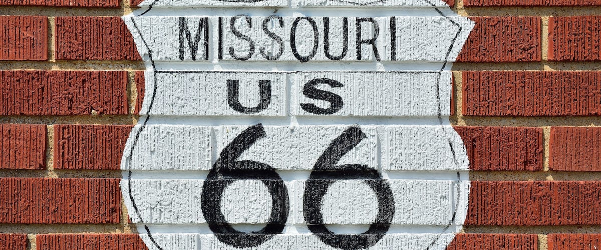 A brick wall with a white sign that reads "Missouri US 66".