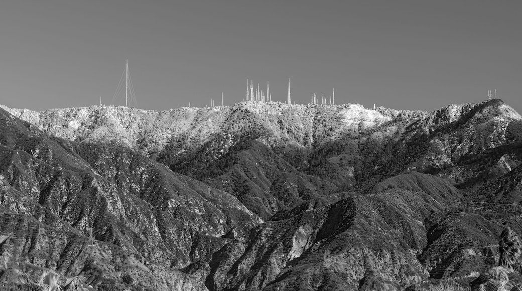 Un paysage montagneux avec, au loin, la silhouette d’une ville.