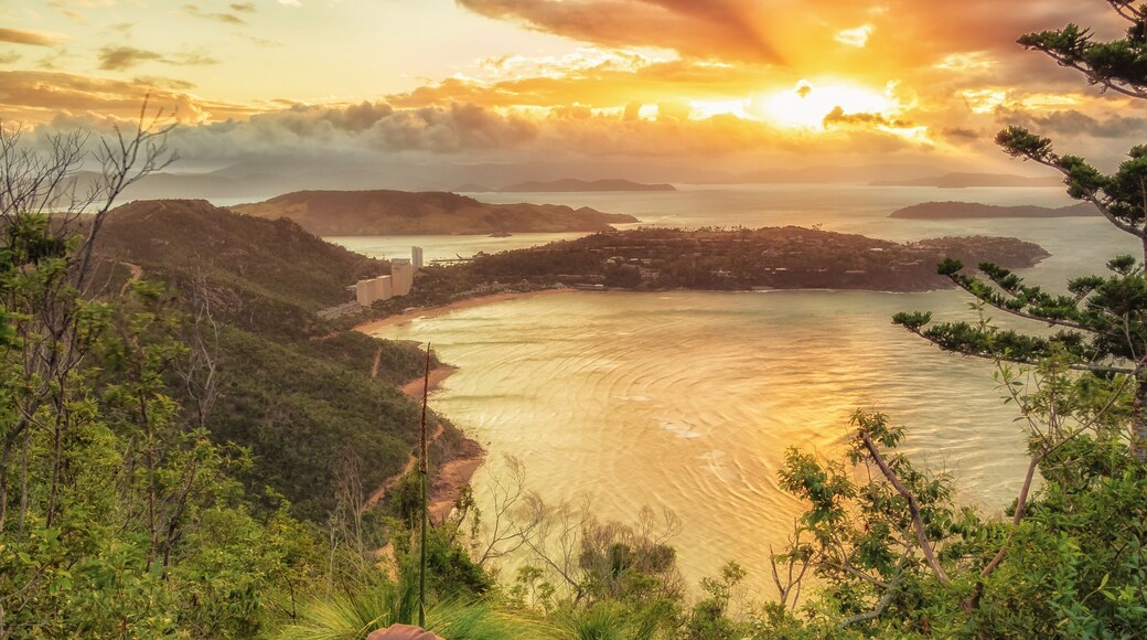 After a hike up Passage Peak on Hamilton Island, a walker rests and watches the sunset