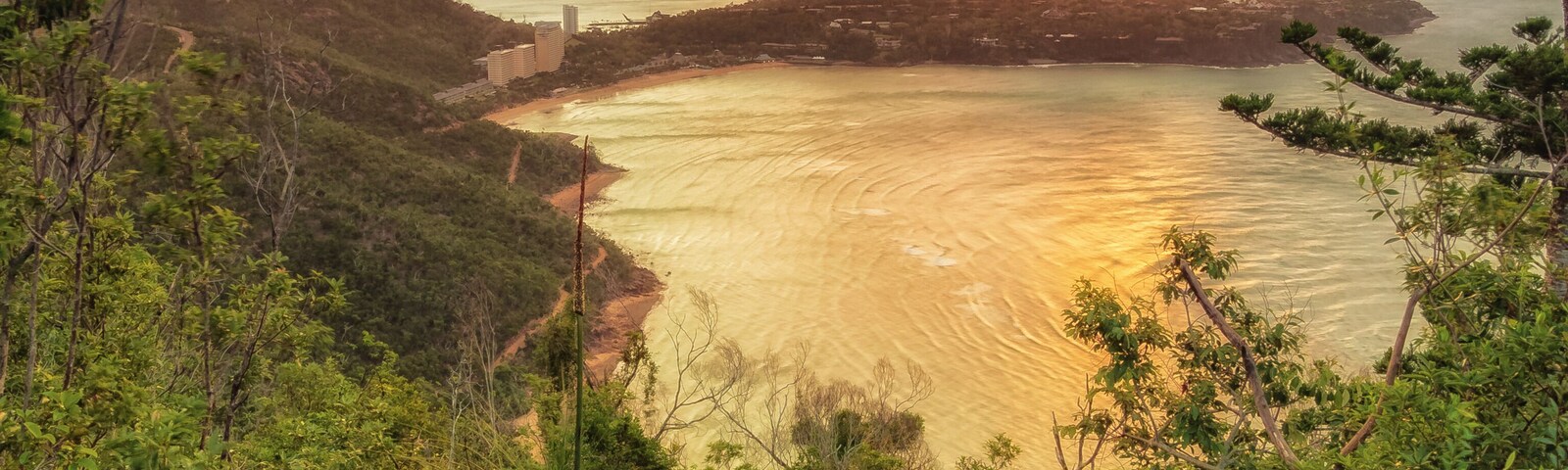 After a hike up Passage Peak on Hamilton Island, a walker rests and watches the sunset