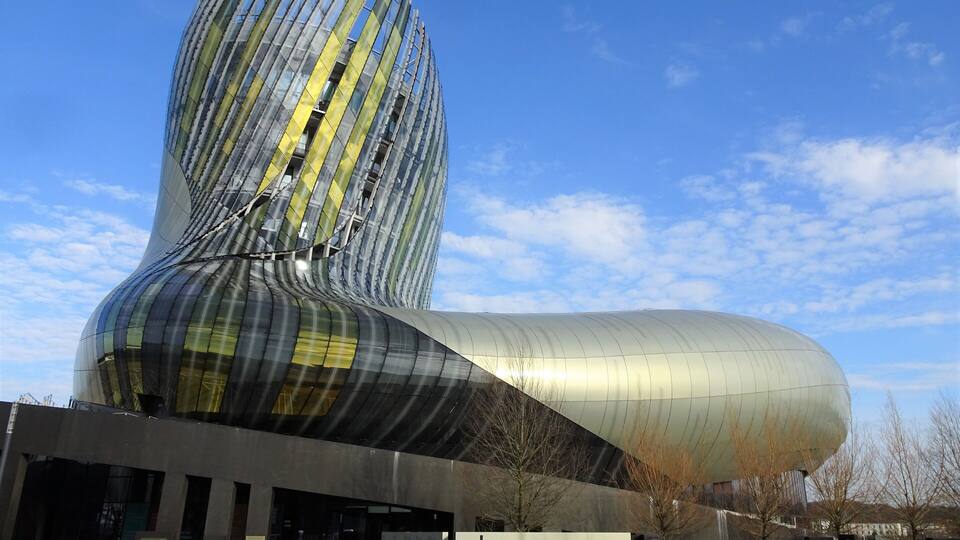A modern architectural building with a curved design and reflective surfaces.