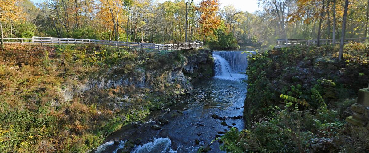 A waterfall in a forested area with wooden walkways.