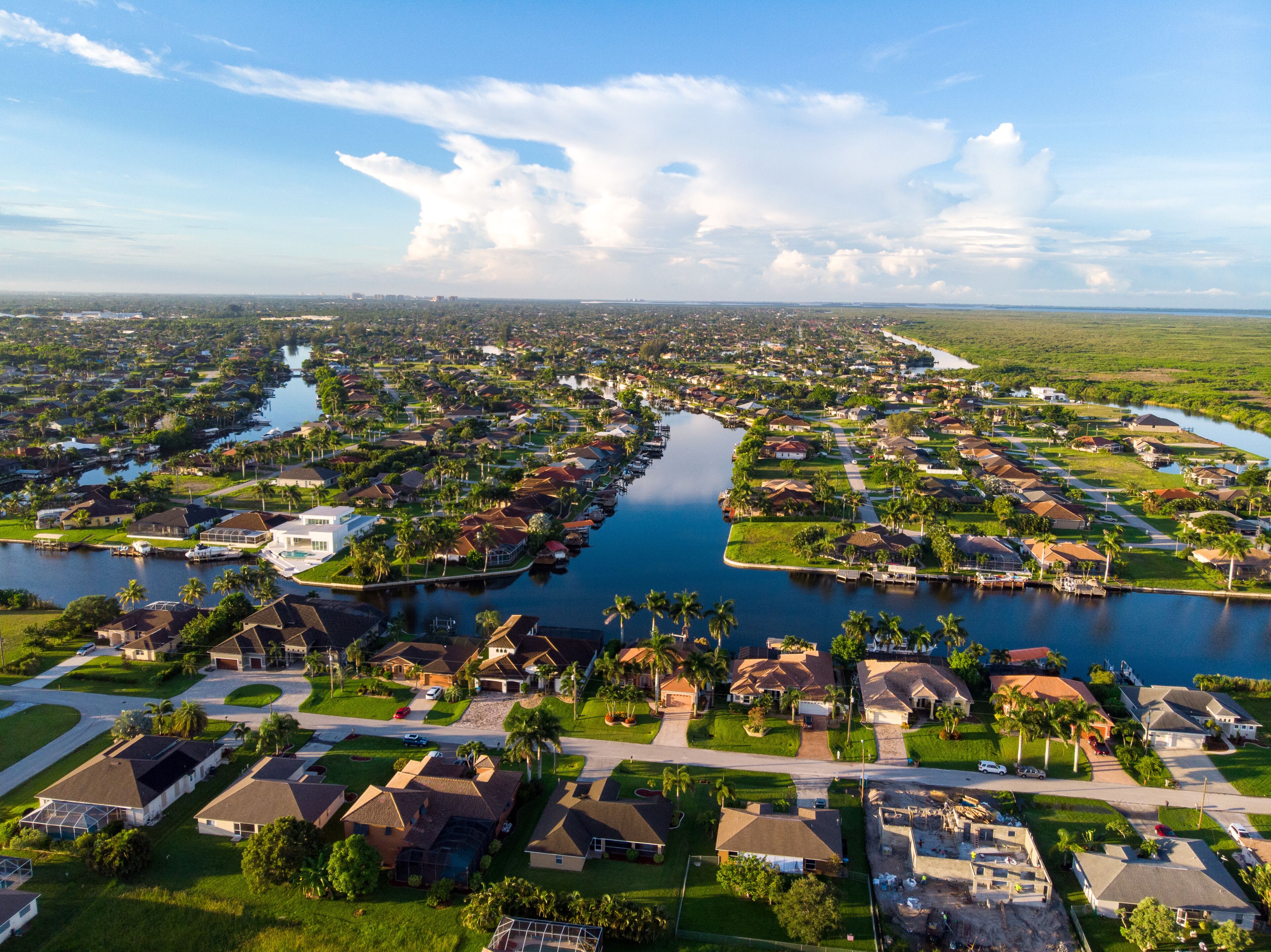 A residential area with houses, a river, and a clear sky.