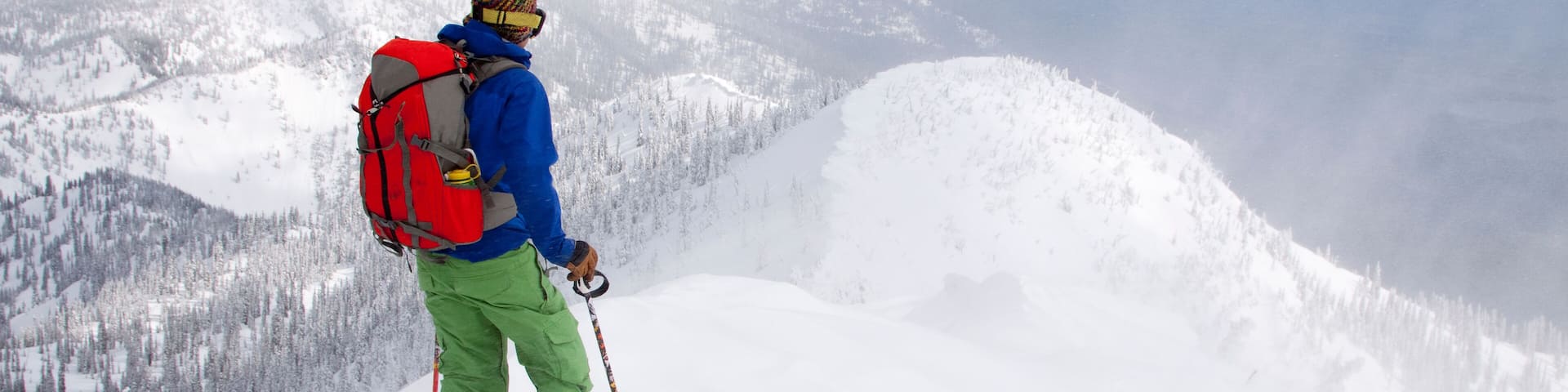 A backcountry skier at the top of a ridge near Columbia Falls, Montana.