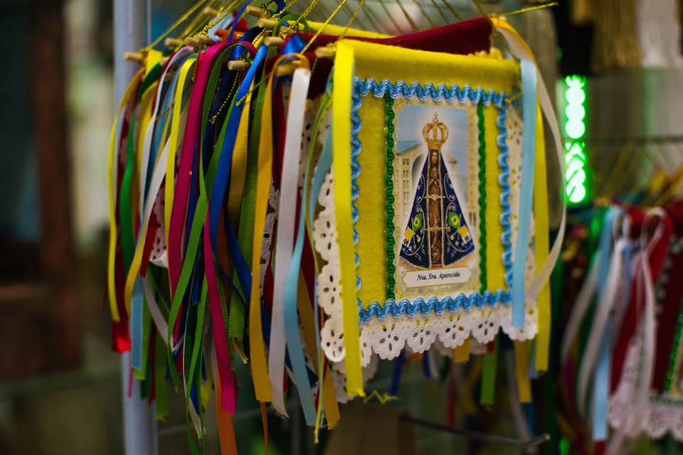 Um colorido conjunto de fitas e um quadro com a imagem de uma figura religiosa.