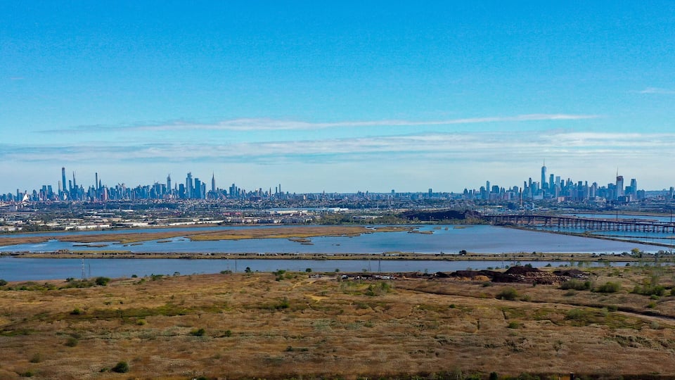 A city skyline with a river and a bridge.