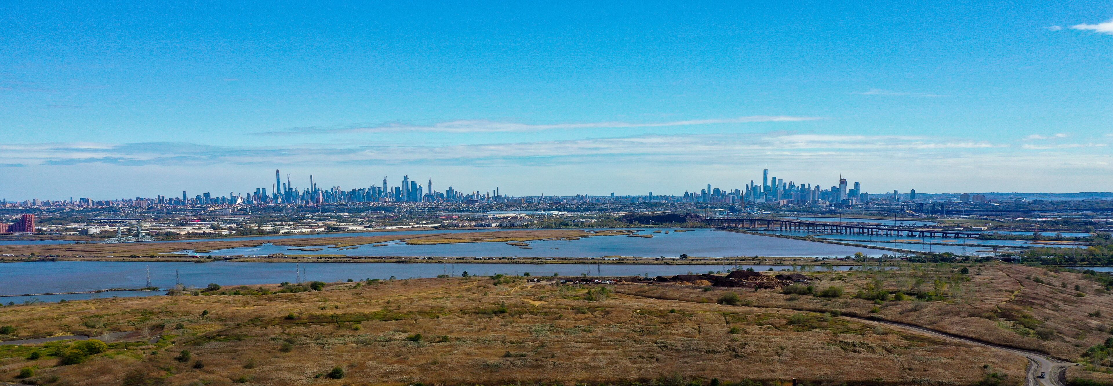 A city skyline with a river and a bridge.