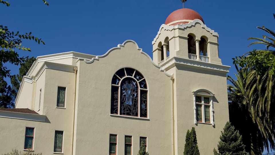 A building with a red dome, arched windows, and a bell tower.