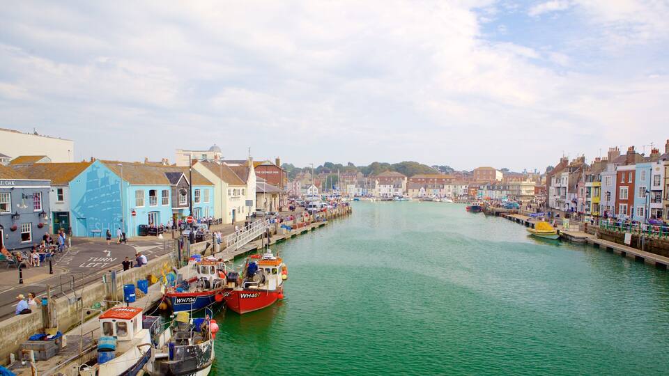 A harbor with boats docked along the waterfront, colorful buildings, and a clear sky.