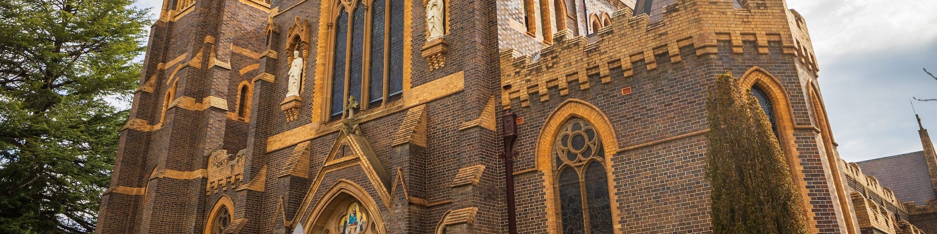 Una iglesia de estilo gótico con elaborados ladrillos, arcos apuntados y una torre destacada.