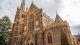 A Gothic-style church with intricate brickwork, pointed arches, and a prominent tower.