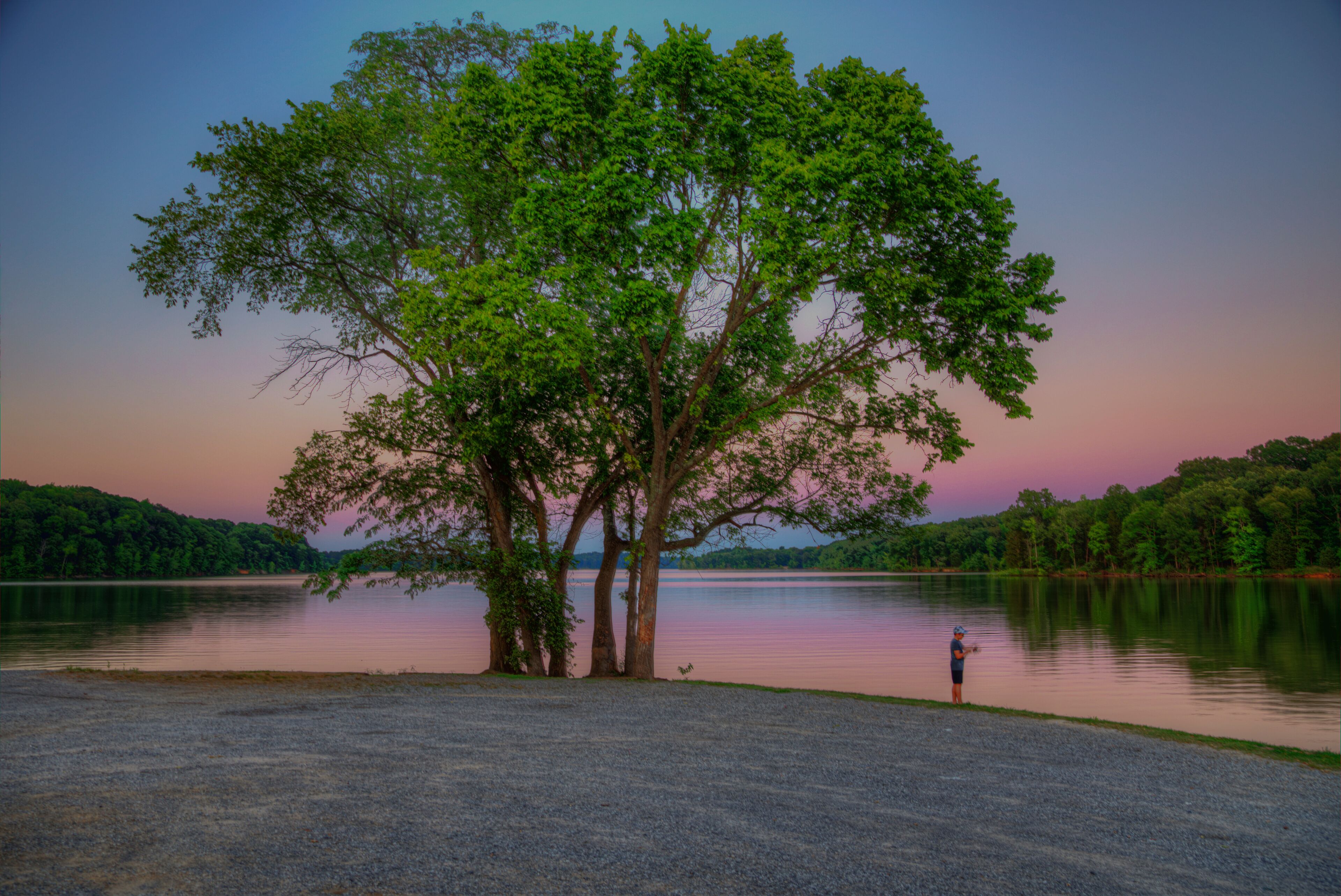 Fishing at Sunset  Crooked Creek Bay Lake Barkley Kentucky  A young fisher tries his luck in the late evening hours after sunset during the blue hour of the day.  