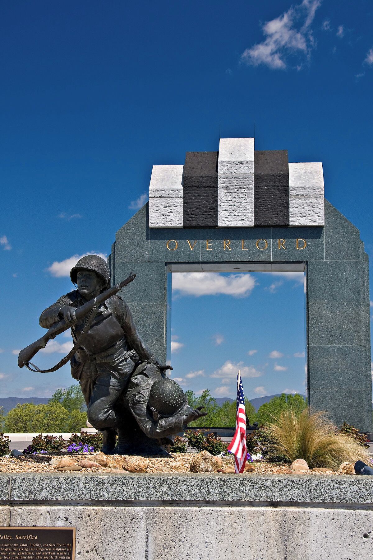 The National D-Day Memorial is an awe-inspiring tribute to the D-Day Invasion, the largest amphibious military landing the world has ever seen. Bedford, Virginia, was chosen as the location of the memorial because the community of Bedford suffered the highest per-capita D-Day losses in the nation.

The memorial is spread over 88 acres and is divided into patterns which represent the various stages or aspects of the invasion.

The centerpiece of the memorial is the Victory Plaza arch, which can be seen for miles. The arch contains a single word, Overlord, referring to Operation Overlord, the code name of the Battle of Normandy. The arch is crowned with five chiseled elements designed to resemble the roofs of houses seen by airborne troops as they passed over the Normandy countryside on the eve of D-Day. The chiseled elements are painted in a black and white pattern, just like the stripes painted on the wings of Allied aircraft.