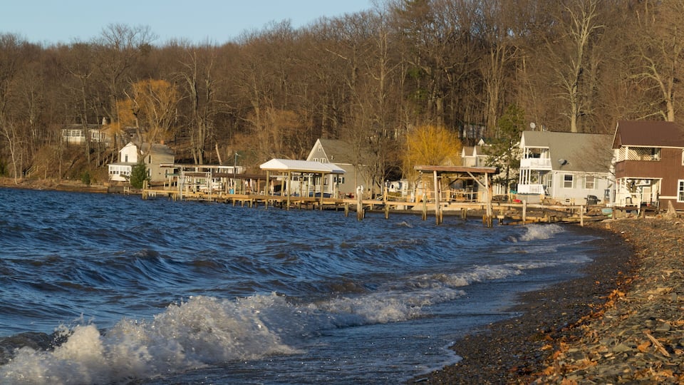 A waterfront with wooden docks and houses along the shore.