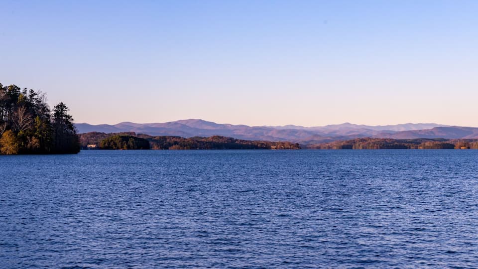 A calm lake with mountains in the background.